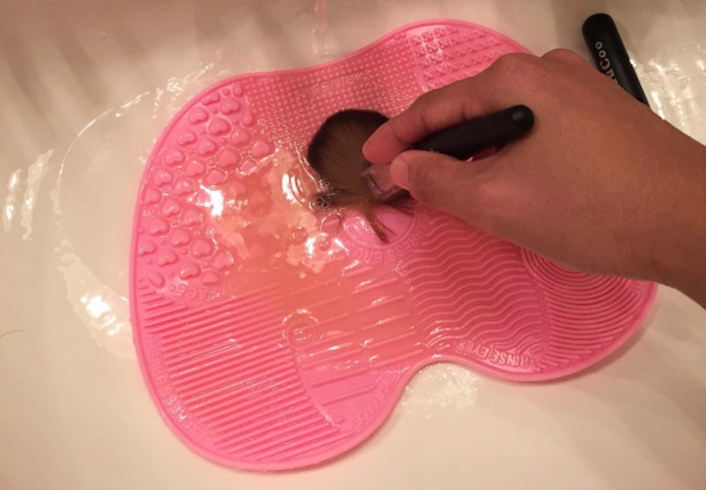 pink make up brush mat in sink