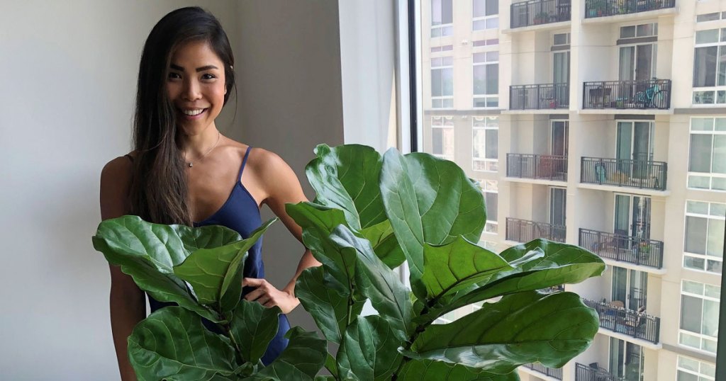 Woman behind green plant