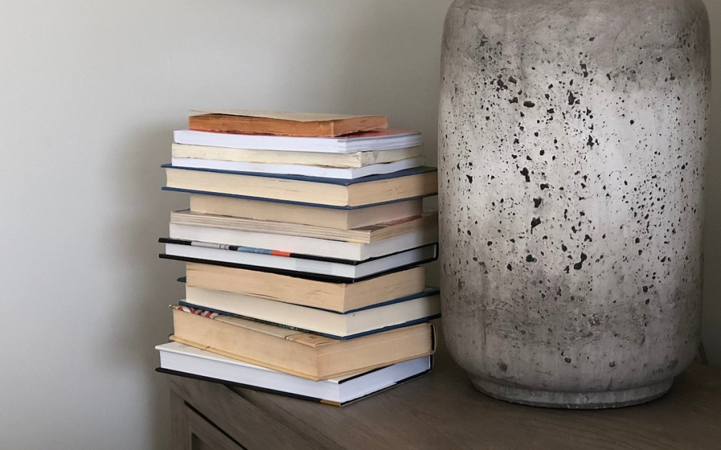 stack of books next to stone lamp