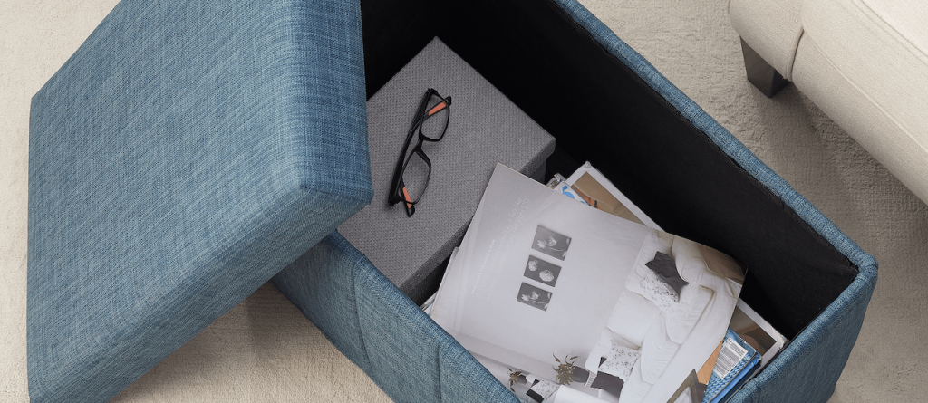 opened storage ottoman with items inside 