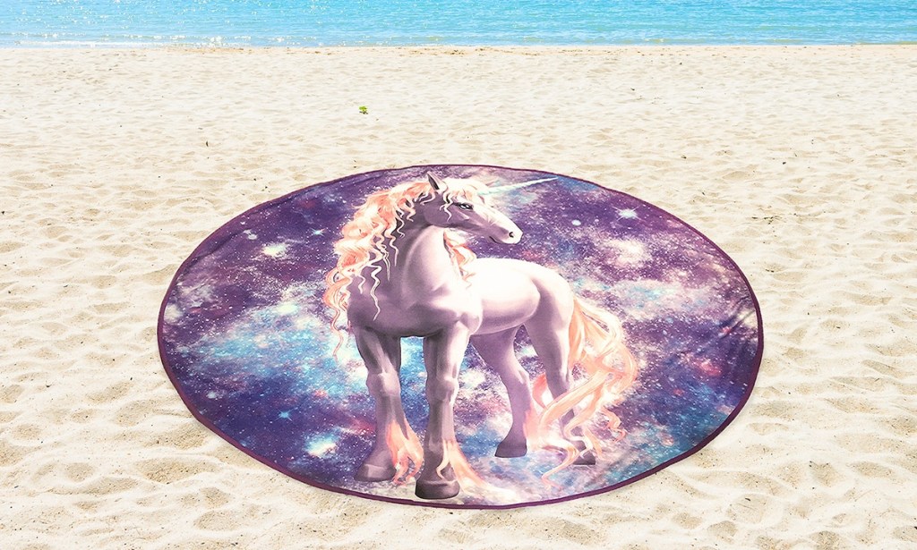 oversized circular unicorn towel on beach