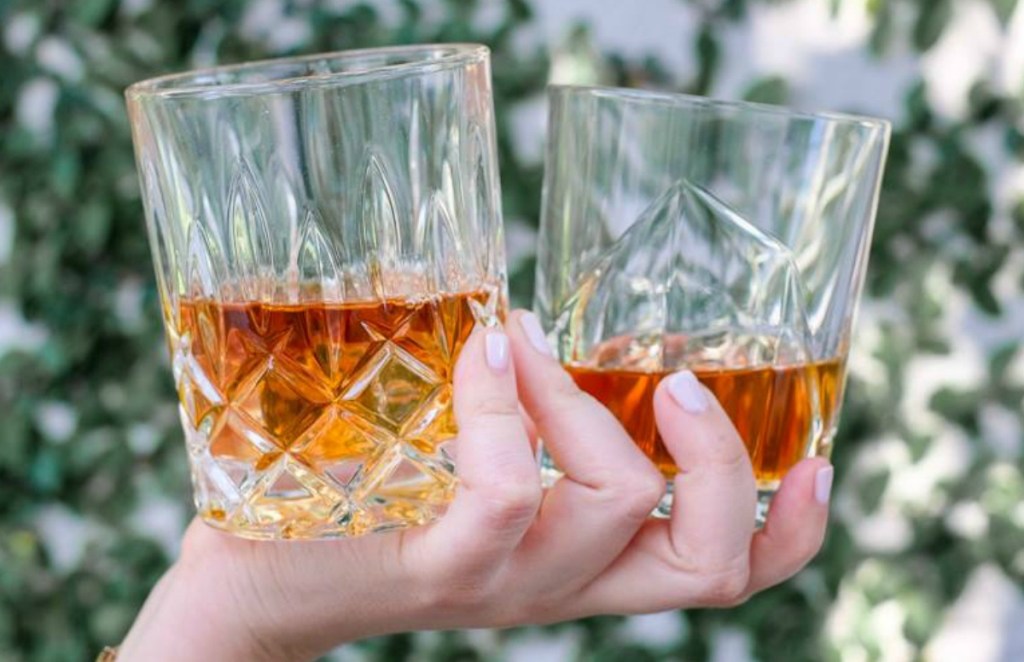 hand holding two vintage glasses