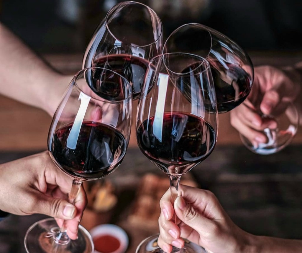 hands holding wine glasses
