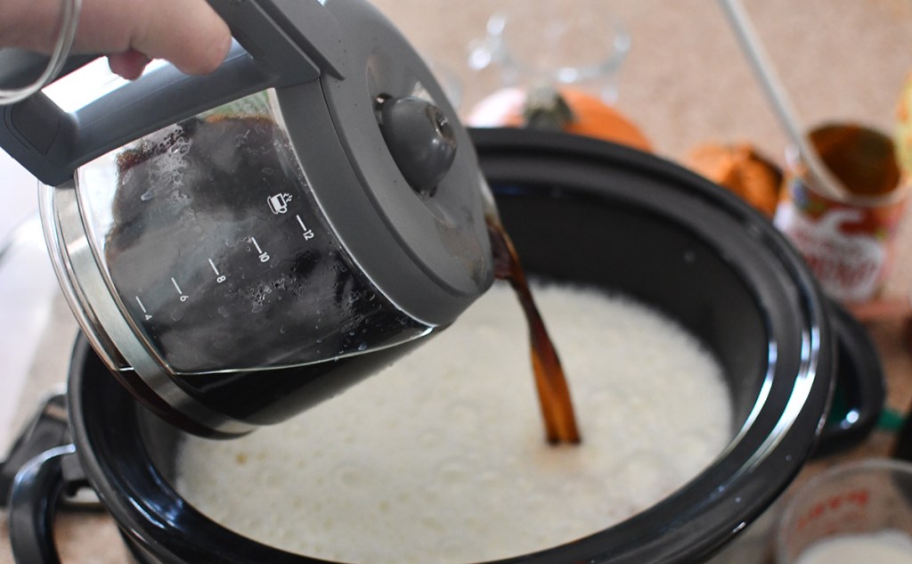 pouring pot of coffee into crockpot