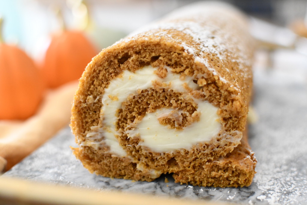 close up of pumpkin roll with cream cheese frosting 