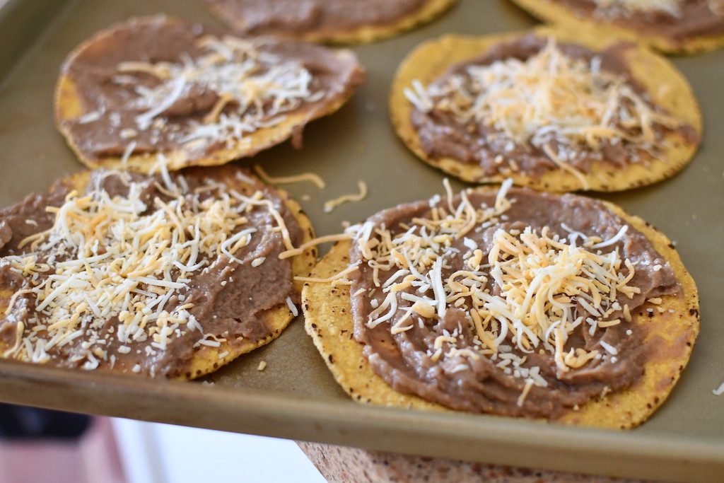 refried beans on tostitos with shredded cheese 
