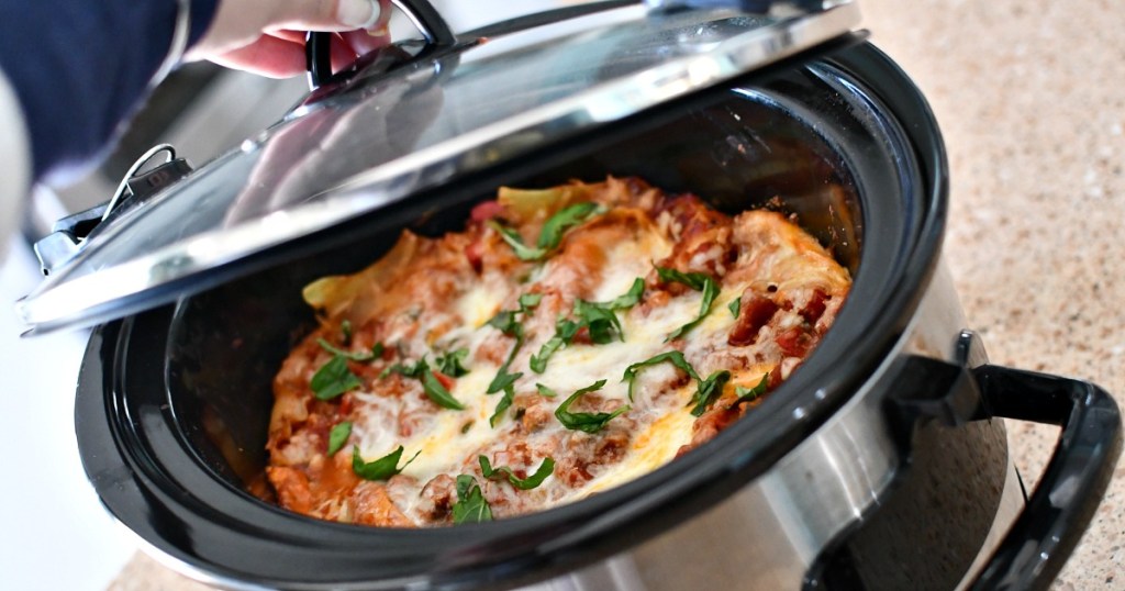 opening a slow cooker with lasagna in it