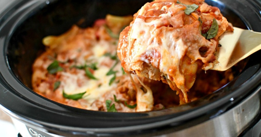 person dishing up lasagna from the slow cooker