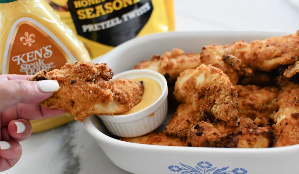 dipping chicken tenders in honey mustard dressing