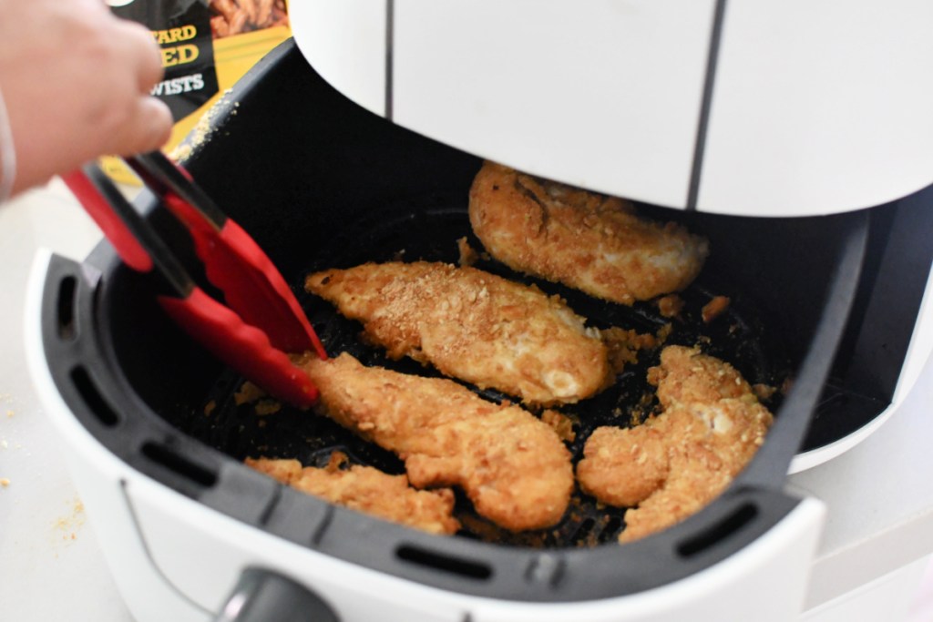 using tongs on honey mustard chicken in the air fryer