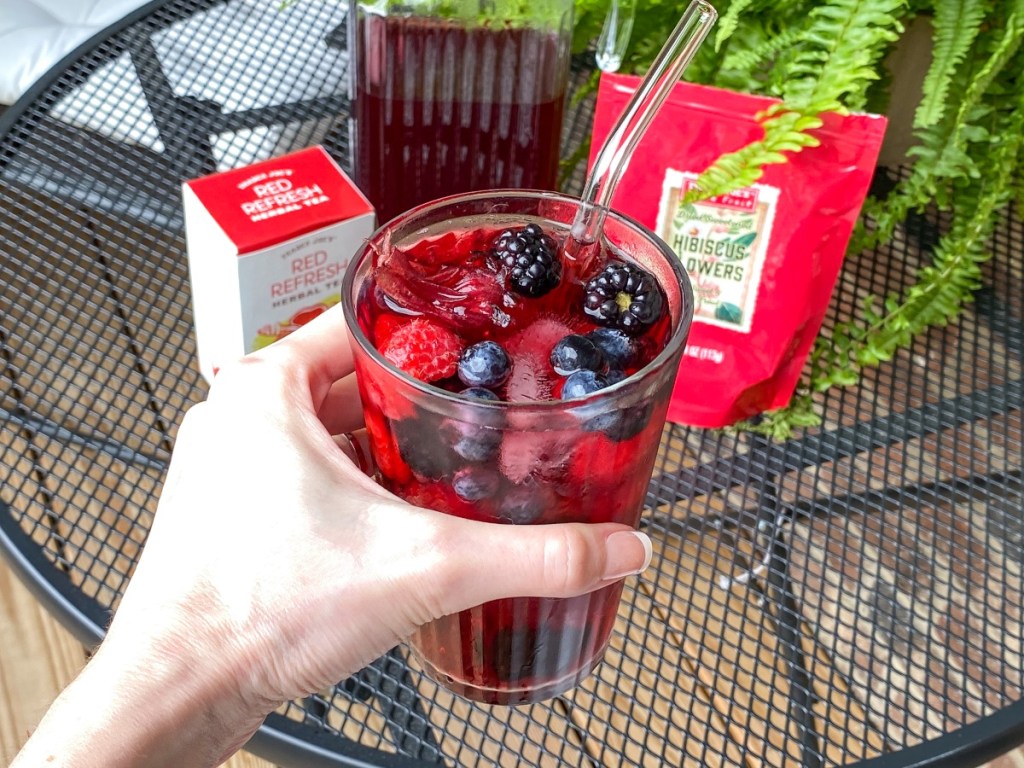 hand holding red drink with berries