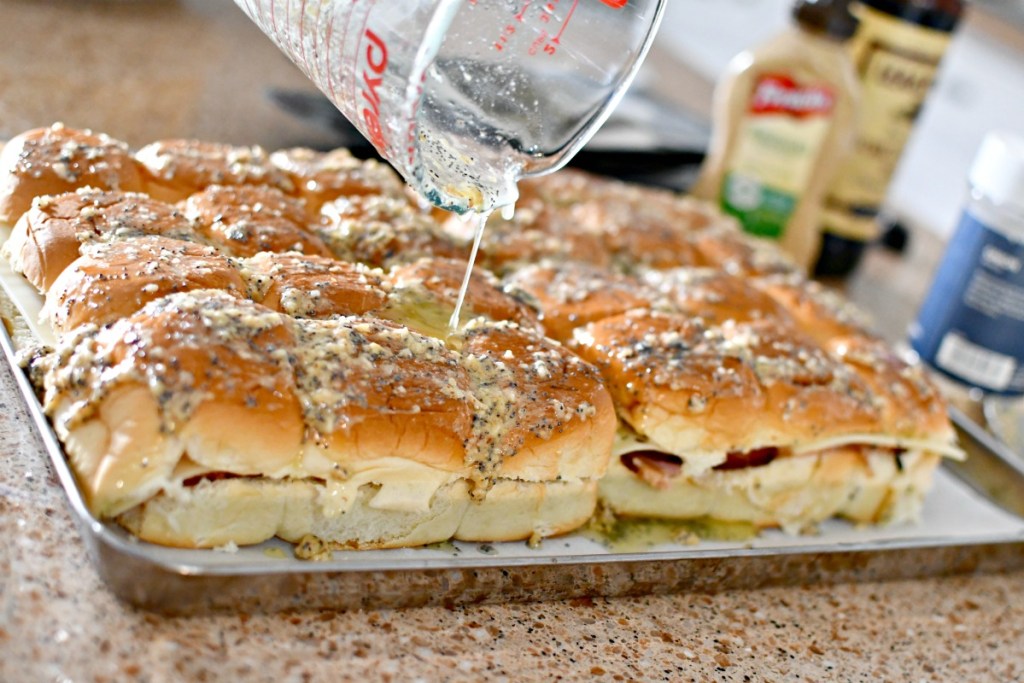 pouring butter mixture over party sliders