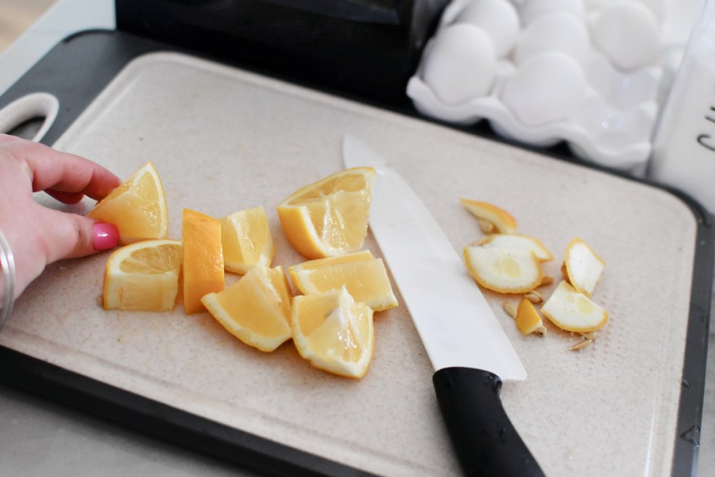 cutting up a lemon on a cutting board 