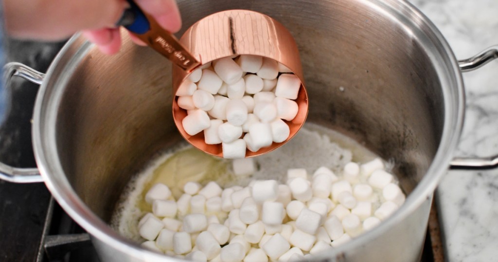 adding marshmallows to melted butter