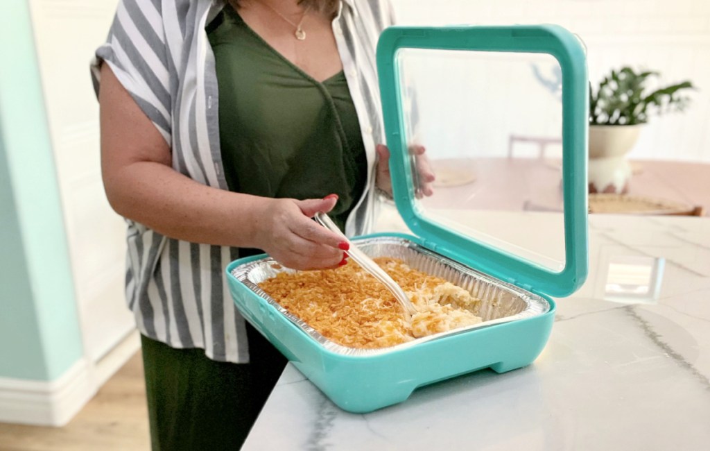 woman holding a fancy panz foil pan dish cover