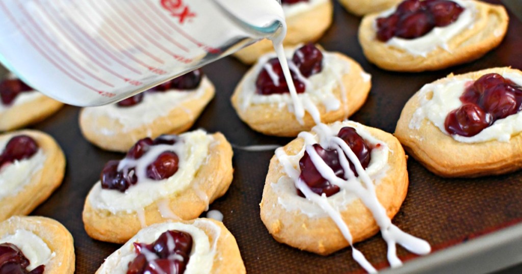 drizzling cream cheese over cherry danish