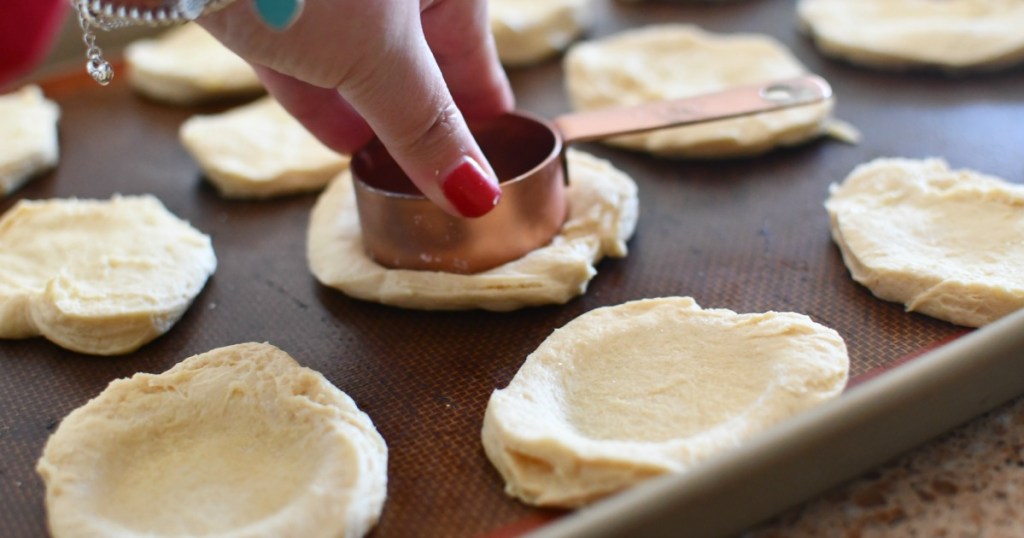 pressing a dent in the biscuit dough