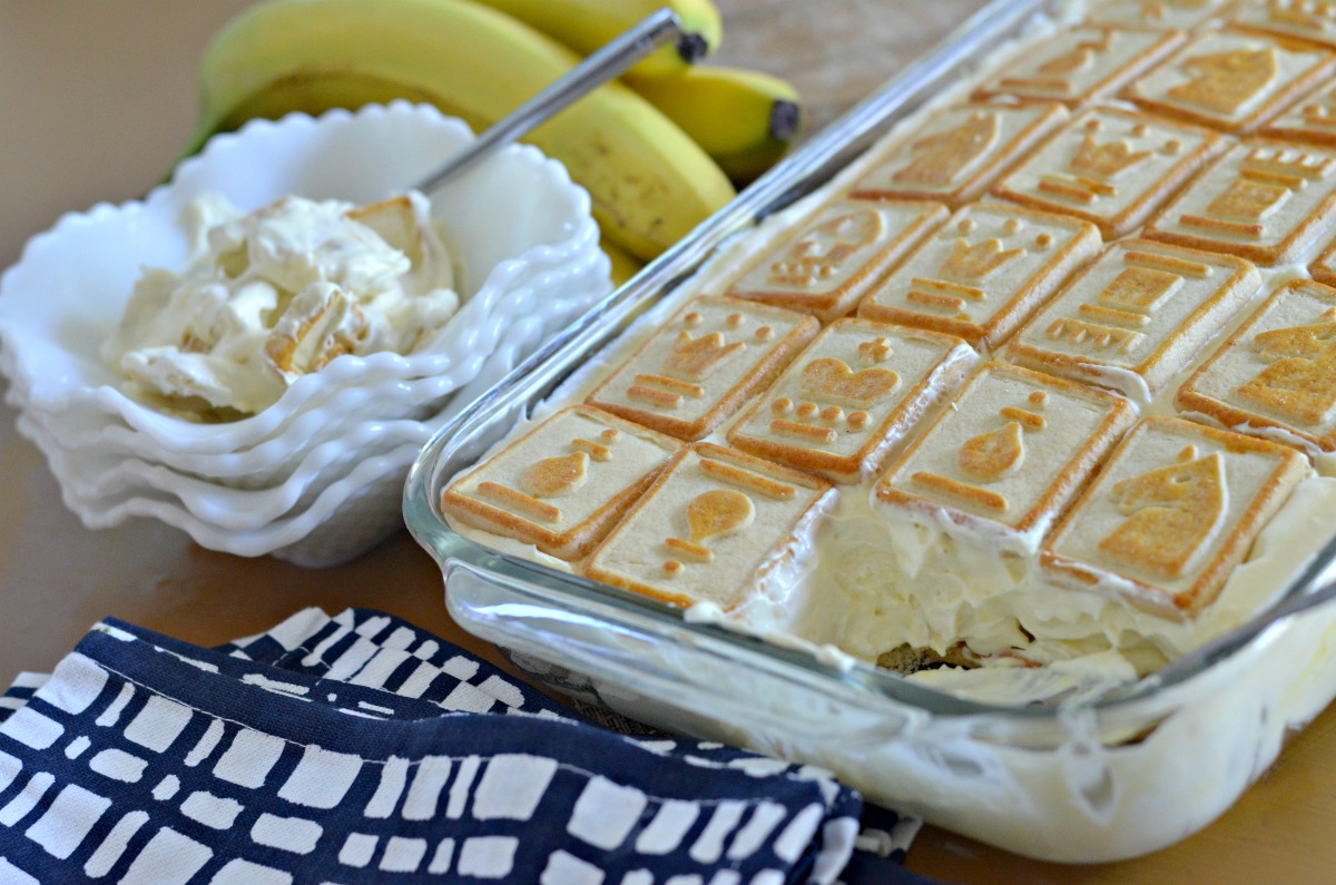 pan of banana pudding next to a stack of bowls