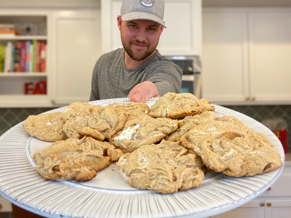 man holding out plate of fluffernutter cookies 