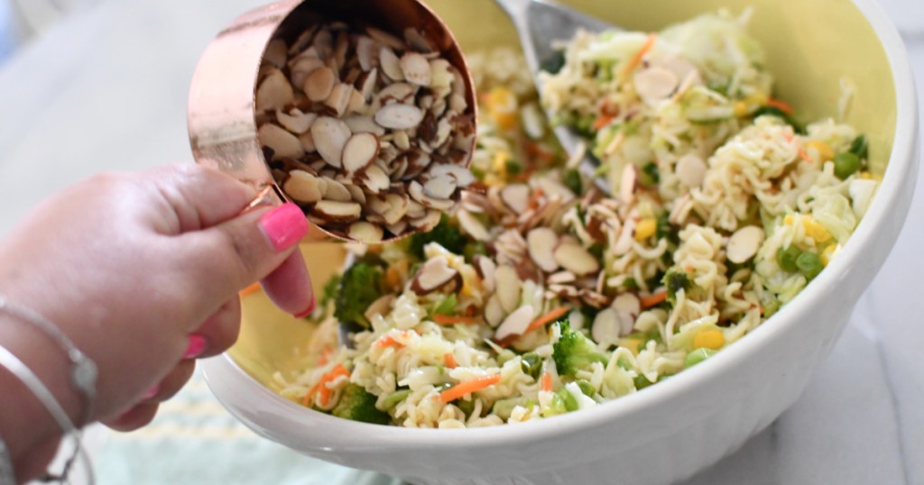 adding sliced almonds to ramen noodle salad