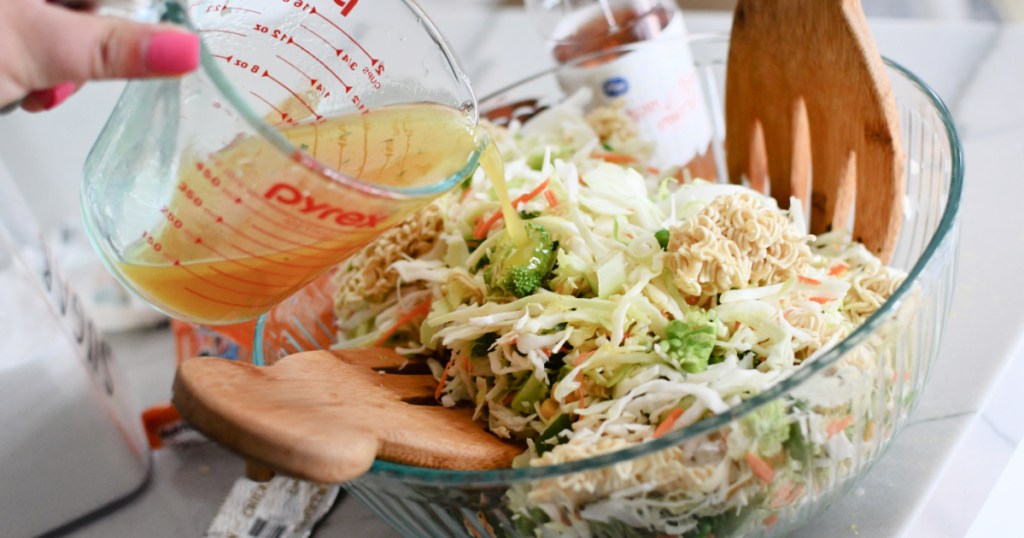 pouring dressing on ramen noodle salad