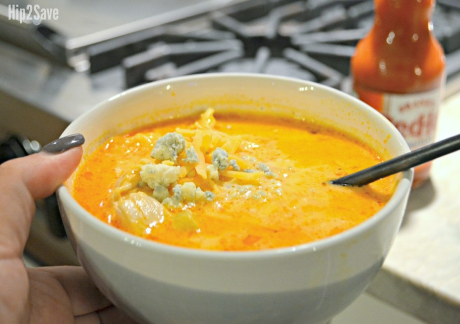 holding a bowl of keto buffalo chicken soup