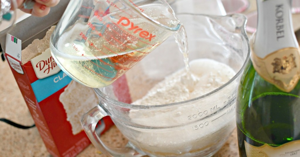 pouring champagne in cake mix to make cupcakes