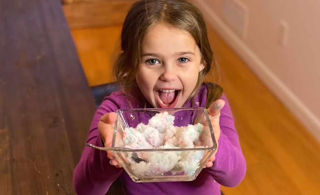 A little girl holding a bowl of snow ice cream