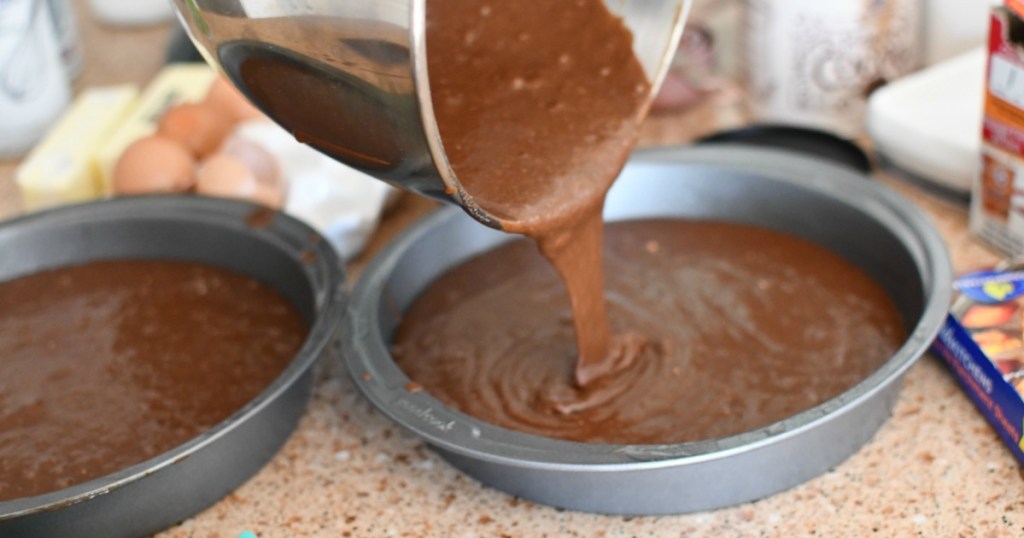 pouring cake batter into cake pans