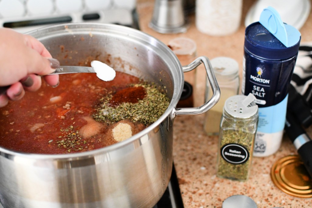 adding seasonings to goulash