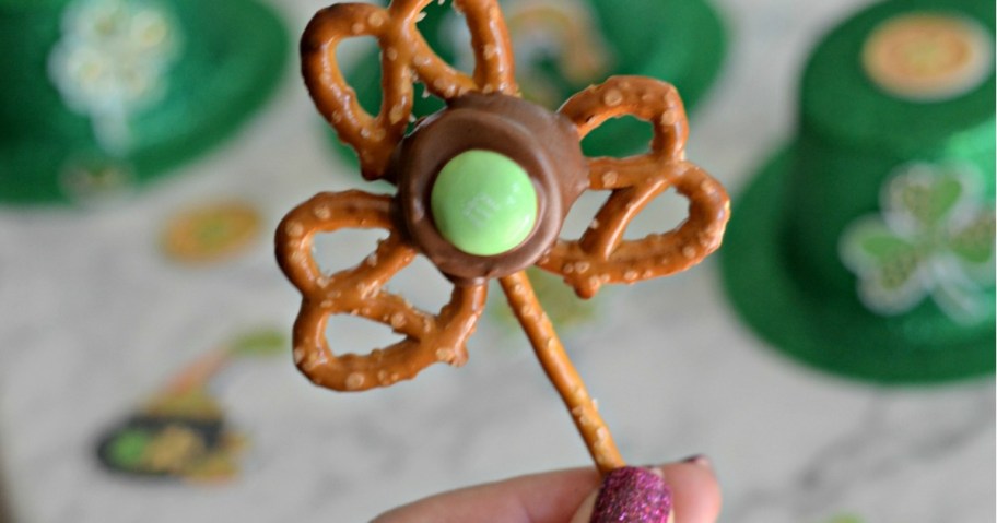 Hand holding up an easy Shamrock Pretzel served as st patrick's day shamrock snacks