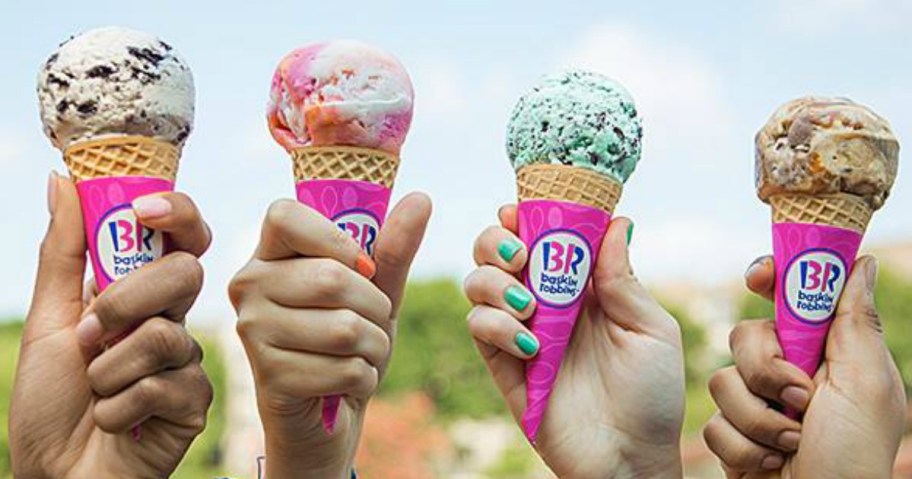 four people holding up ice cream cones