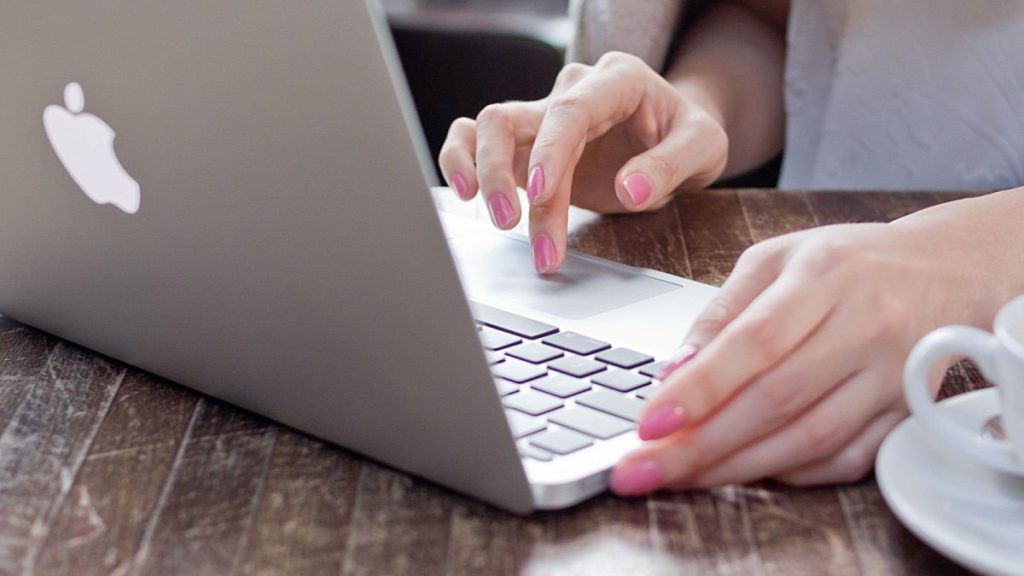 woman typing on macbook