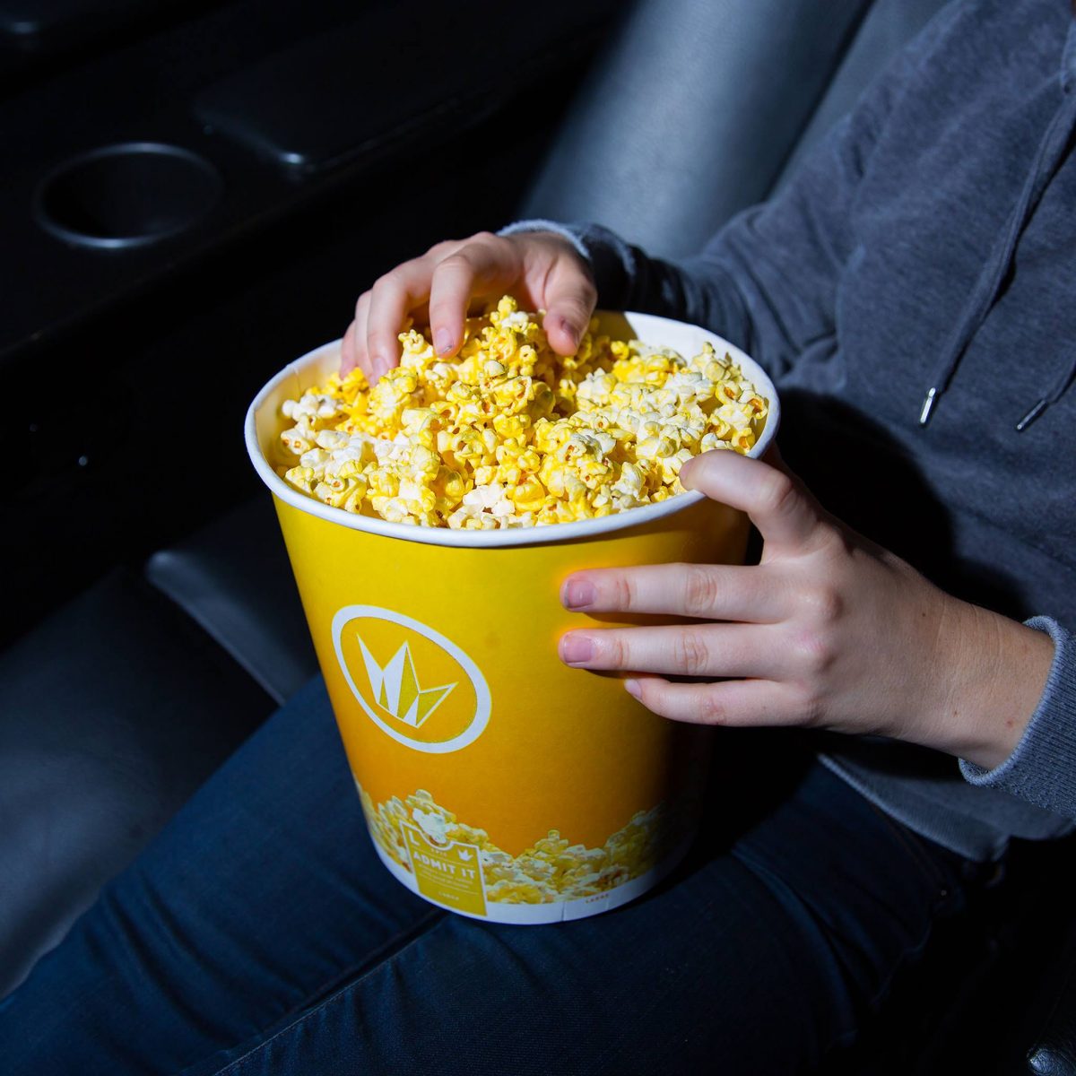 a moviegoer holding popcorn