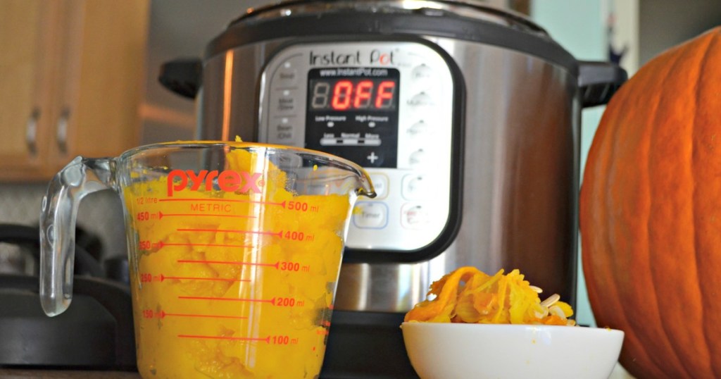 pumpkin puree in measuring cup next to an Instant Pot