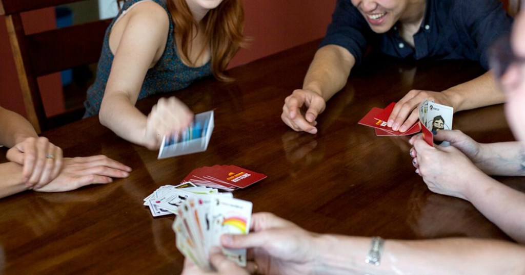 family playing a game of exploding kittens on a table