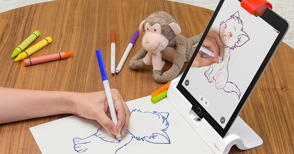 kid's hand drawing a kitten in front of Osmo Genius Kit