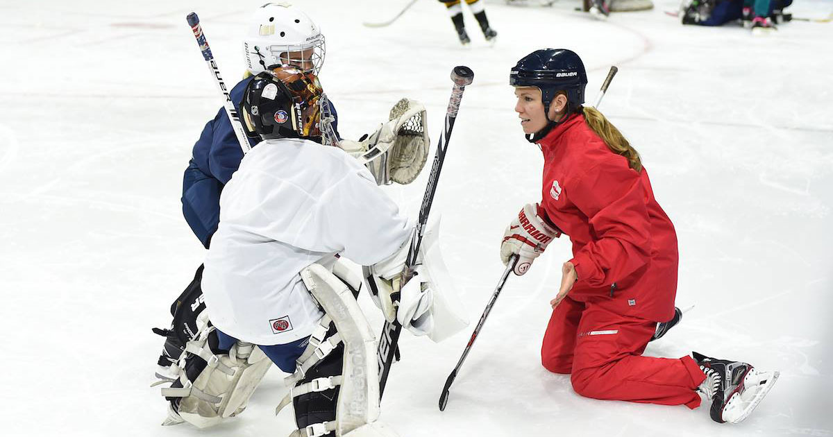 three young kids playing ice hockey