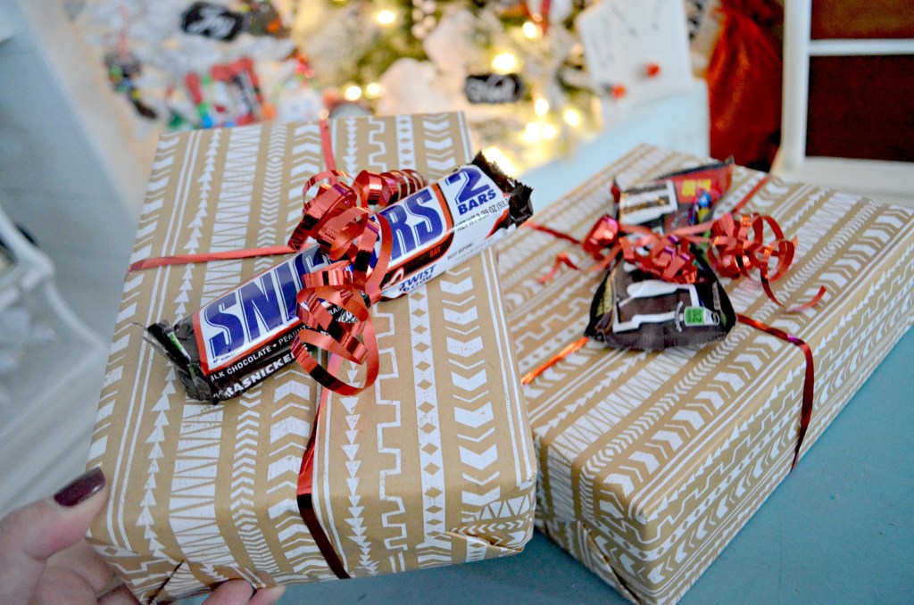 Christmas gifts wrapped with candy bars on top 