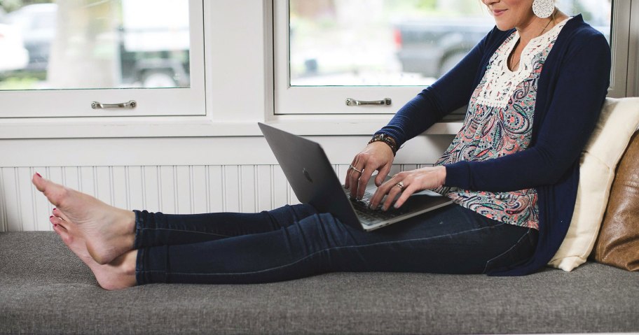 woman with laptop near window