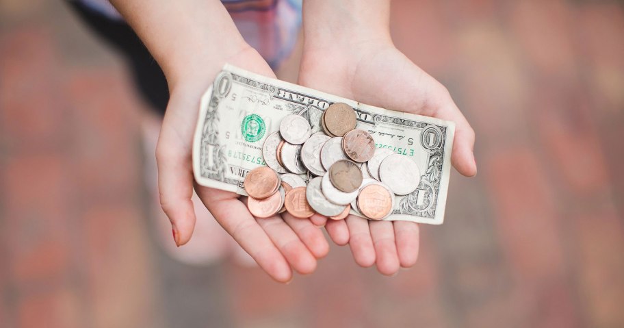 person holding out hands with cash and coins