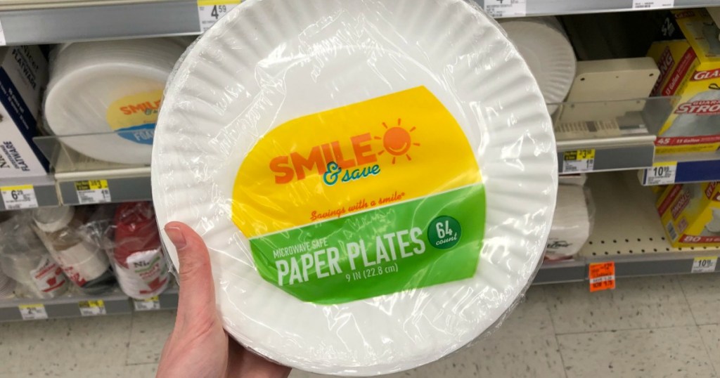 hand holding white paper plates 