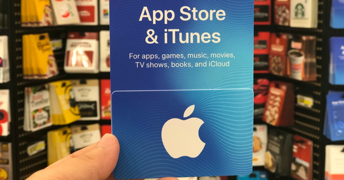 someone holding an Apple itunes gift card at a store