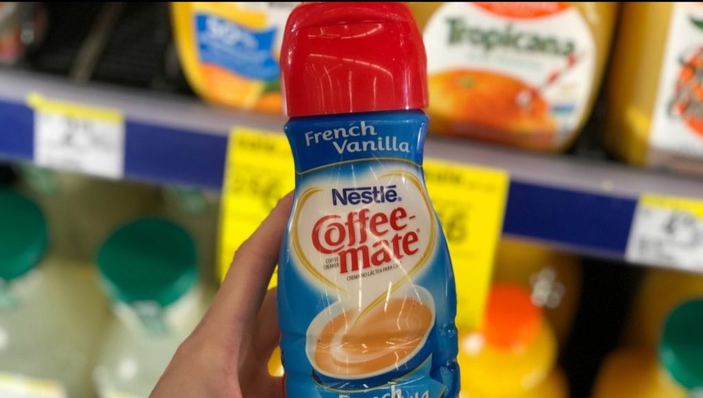 hand holding bottle of coffee creamer