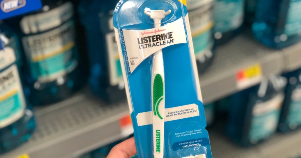 holding a Listerine flosser