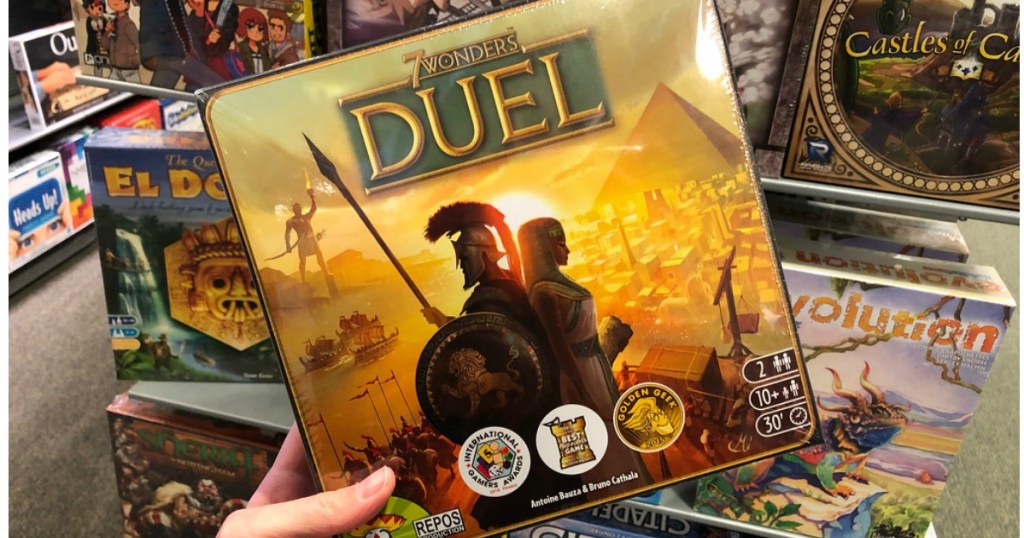 hand holding up 7 wonders duel game in store