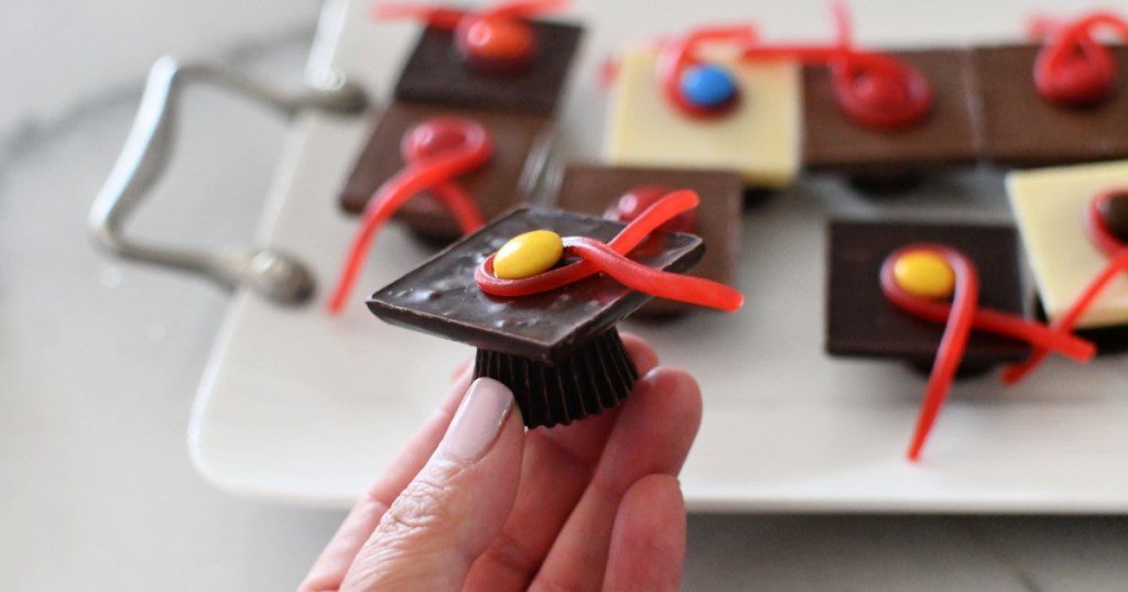 holding a chocolate graduation cap