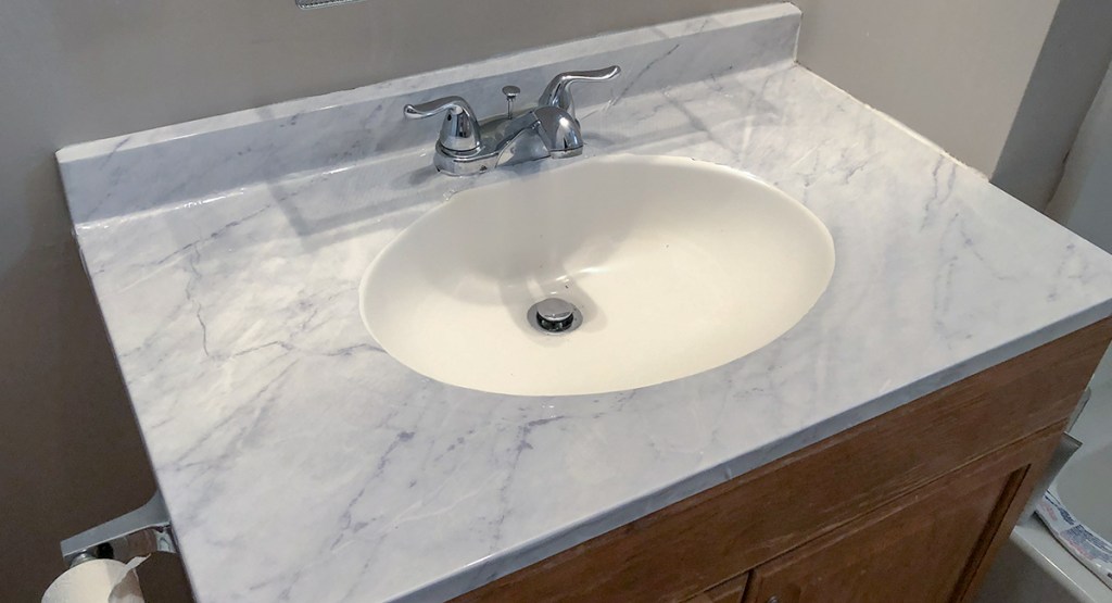 marble countertop DIY - using sharp tool, cut close to sink basin edge