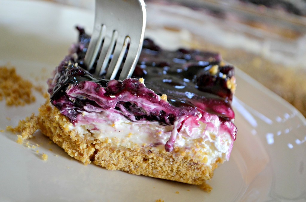 fork in a blueberry cheesecake square
