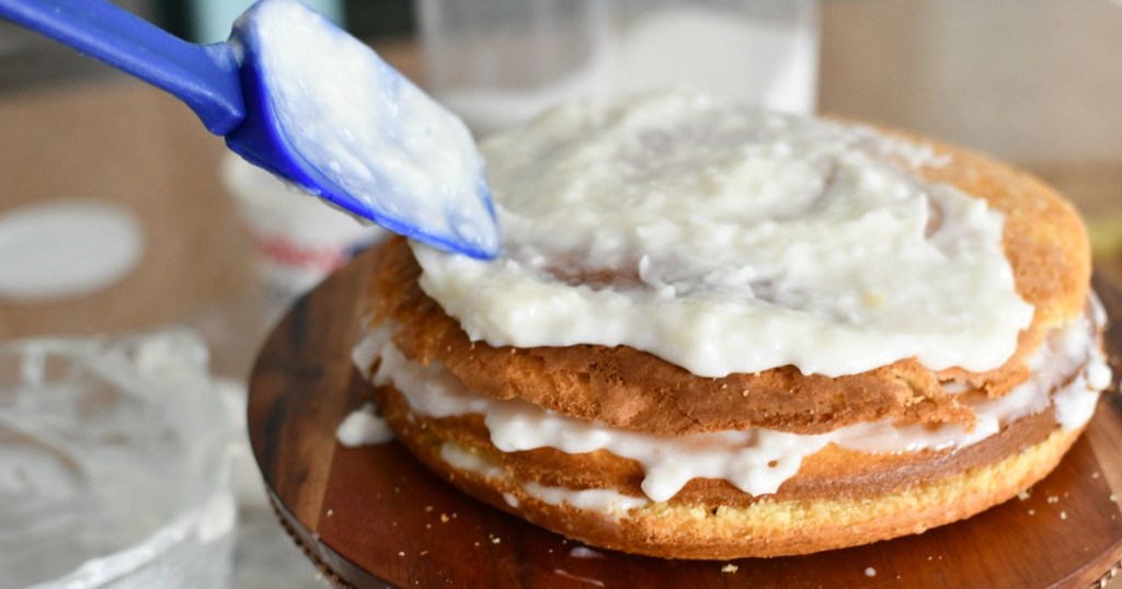 layering sour cream with coconut and sugar onto cake